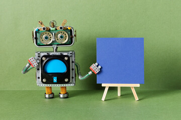 The robot and blue paper placard set on wooden easel. copy space for text. Green background