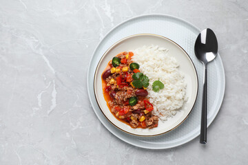 Plate of rice with chili con carne on light grey table, top view. Space for text