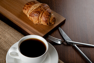 Croissant with a cup of full coffee,directly above	