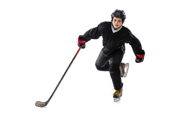 Fototapeta premium Active player. Sportive boy, child, hockey player in special uniform training, practising isolated over white studio background.