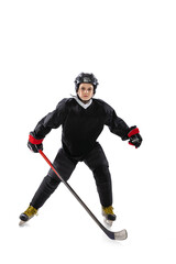 Portrait of child, hockey player standing on goalkeeper position, training isolated over white studio background