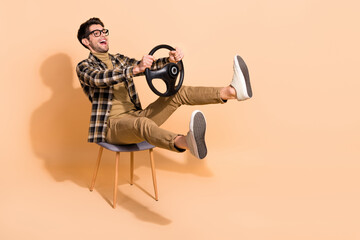 Full length profile side photo of amazed guy sit chair enjoy dream car ride isolated pastel color...