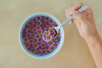 Its a culinary and visual feast. High angle shot of an unrecognizable man eating a bowl full of pretty pink flowers.