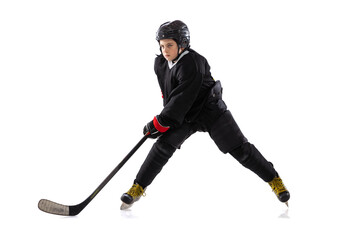 Obraz premium Dynamic portrait of kid, hockey player in black sportswear and helmet training isolated over white studio background