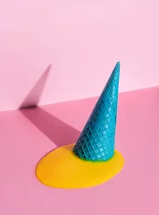  An overturned waffle cone with melted ice cream on a pink background. © Алексей Коза