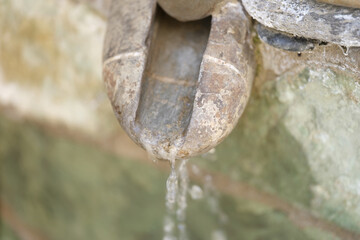 Old vintage stone waterfall pours water closeup