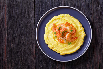 polenta with fried shrimps on plate, top view