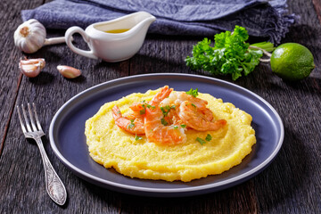 polenta with fried shrimps on plate, top view