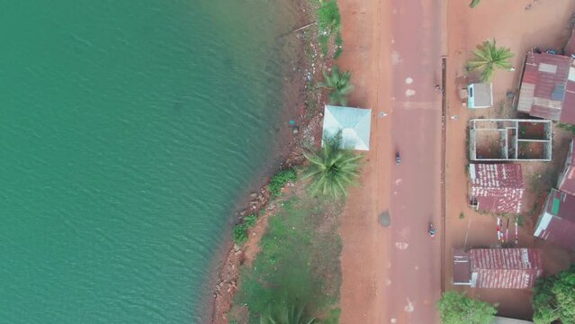 a bike riding along a beautiful street at the coast of West Africa in Robertsport, Liberia