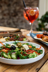 Greek salad with olives and tomato in restaurant on a wooden table