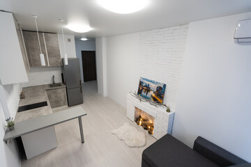 Modern studio flat with small kitchen, sofa.