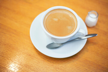 木製のテーブルの上のコーヒーとミルクピッチャー