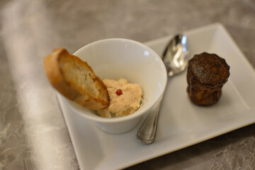 アミューズ。サーモンのリエットとバゲットのトースト。ピンクペッパー。塩味のカヌレ。デミ・スプーン。