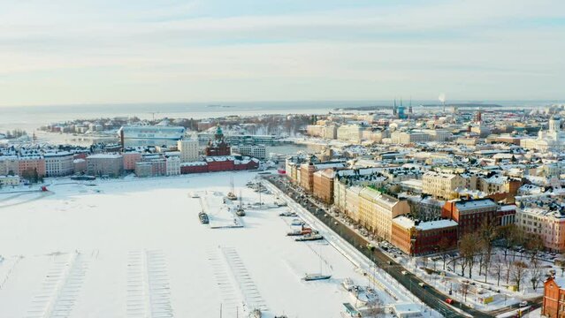 Aerial view Helsinki Finland. Frozen Baltic Sea with boats on the shores of the old town with historic architecture.