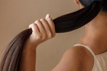Young woman hand holding ponytail in studio