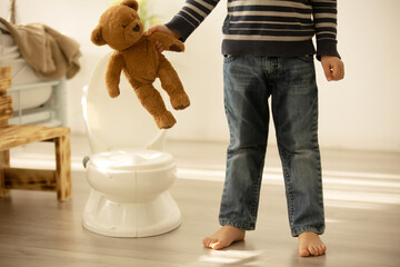 Little toddler child, boy,  pee in his pants while playing with toys, child distracted and forget...