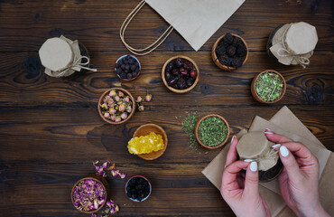 Women's hands tie a jar of collected tea with a string