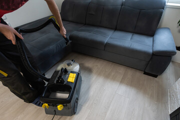 Hand cleaning a sofa with a steam cleaner, Home cleaning concept