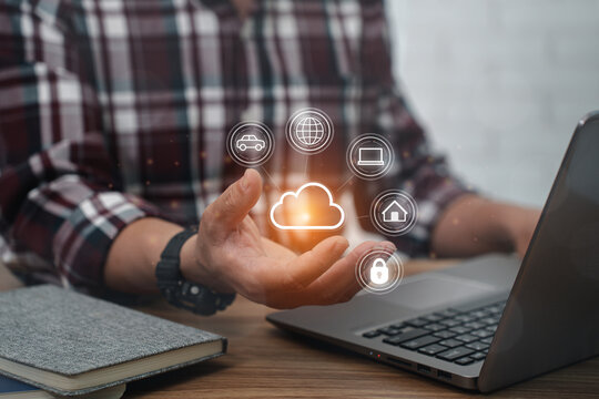 A man wearing a plaid shirt use Laptop with cloud computing diagram on hand : working at home office technology and network concept - Powered by Adobe