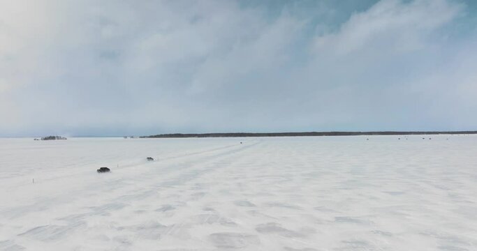 Cars Driving on the frozen lake in Canada, Drone, following the cars, in 4k