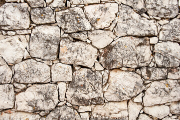 Rugged, white stone wall background texture.