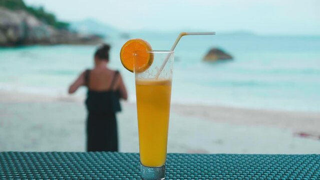juce close-up on the background of the ocean in the tropics on the Seychelles island, cocktail with pineapple and orange fruits