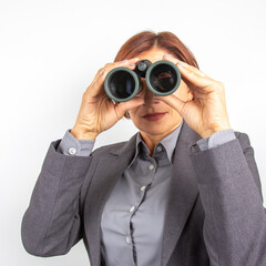 Business woman in suit looking through binoculars