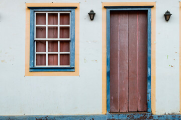 Obraz na płótnie Canvas Ibitipoca, Minas Gerais, Brasil: Faixada da casa com janela e porta nas cores vermelho, azul e amarelo