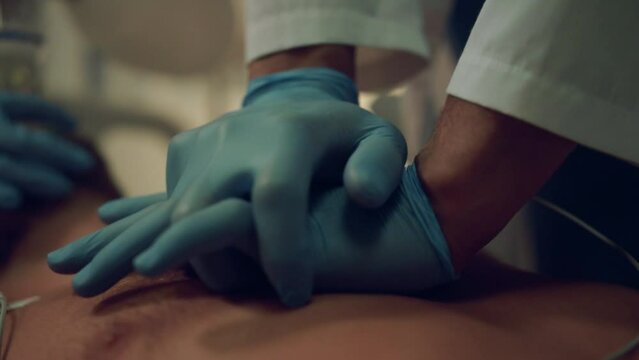 Doctor give resuscitation to dying patient closeup. Cardiac massage in hospital