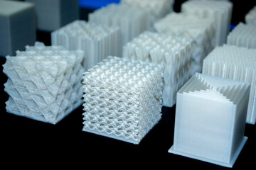 White models prototypes printed on 3D printer from plastic close-up. New progressive additive...