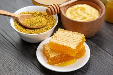 Fresh flower honey of different varieties, pollen and honeycomb with spoons on a wooden background. Organic Vitamin Health Food