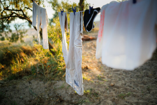 Linen Clothes Are Dried On A Rope Among Trees, Sand And Beach And Clothesline