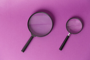 Two magnifying glasses, highlighted on a lilac background. View from above. A place to copy.