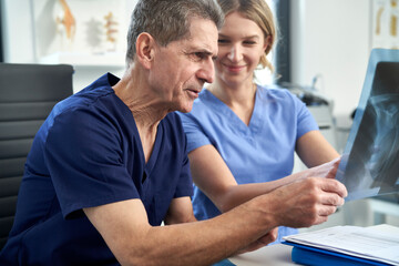 Obraz premium Two caucasian doctors discussing about X-ray image