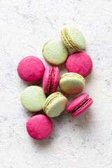Pink and green macaroons on white background. Traditional French sweet dessert.