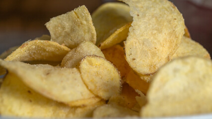 Chips on the plate under sunlight. Potato chips close up