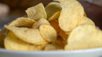 Chips on the plate under sunlight. Potato chips close up