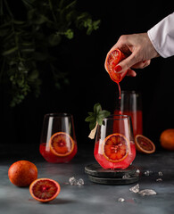 Red citrus photo of orange tangerine gin alcohol cocktail food photo on a table. Tasty citrus beverage banner copy space.