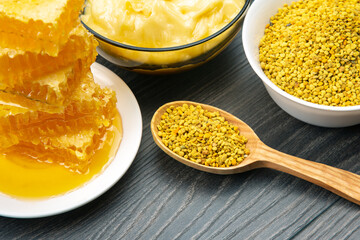 Fresh flower honey of different varieties, pollen and honeycomb with spoons on a wooden background. Organic Vitamin Health Food