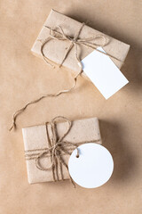 empty white gift tag mock up on craft paper box on natural beige background.