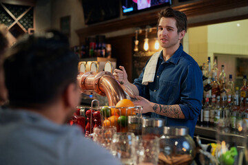 Caucasian of male bartender serving beer at bar