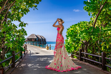 Luxury fashion. Elegant fashion model is posing outdoor. Stylish female model in long gown dress on...