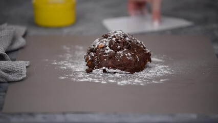 The chef kneads the chocolate and cocoa cookie dough and shapes it.