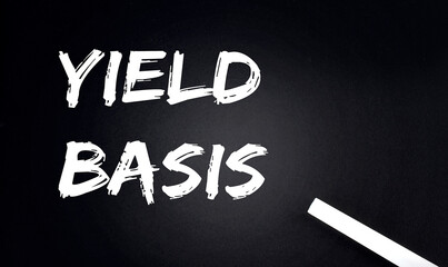 YIELD BASIS Text on a Black Chalkboard with a piece of chalk