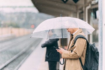 電車のホームで待つ人達