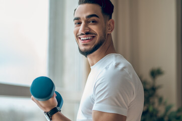 Handsome young man having a workout with dumbbells