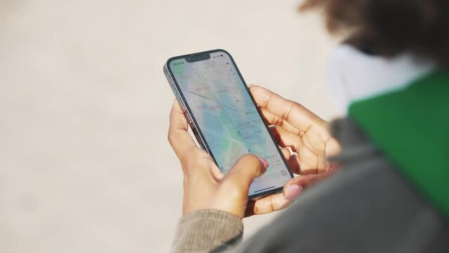 African woman looking at the map on the phone outdoors