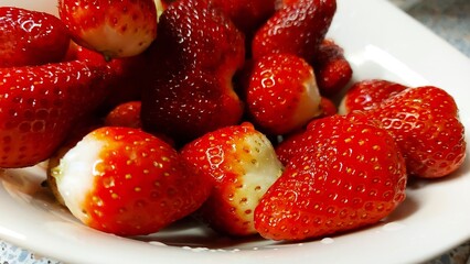 Glänzende Erdbeeren. Rote Früchte in einer weißen Porzellanschale. Direkt über Früchten. Nahaufnahme von Beeren. Quelle natürlicher Vitamine und Mineralstoffe. Antioxidans Nahrung. Erdbeer-Dessert.