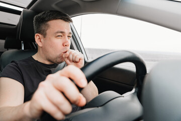 a sleepy and yawning man drives a car on the highway