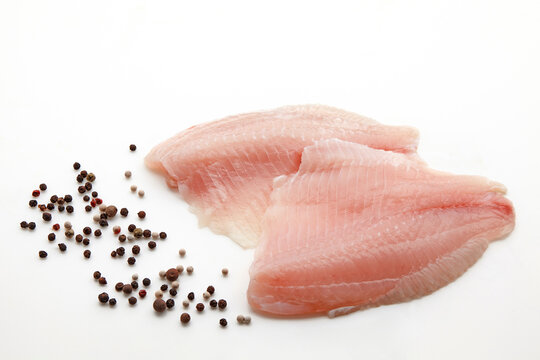 Prepared white fish fillet and pepper drops mix isolated on white background